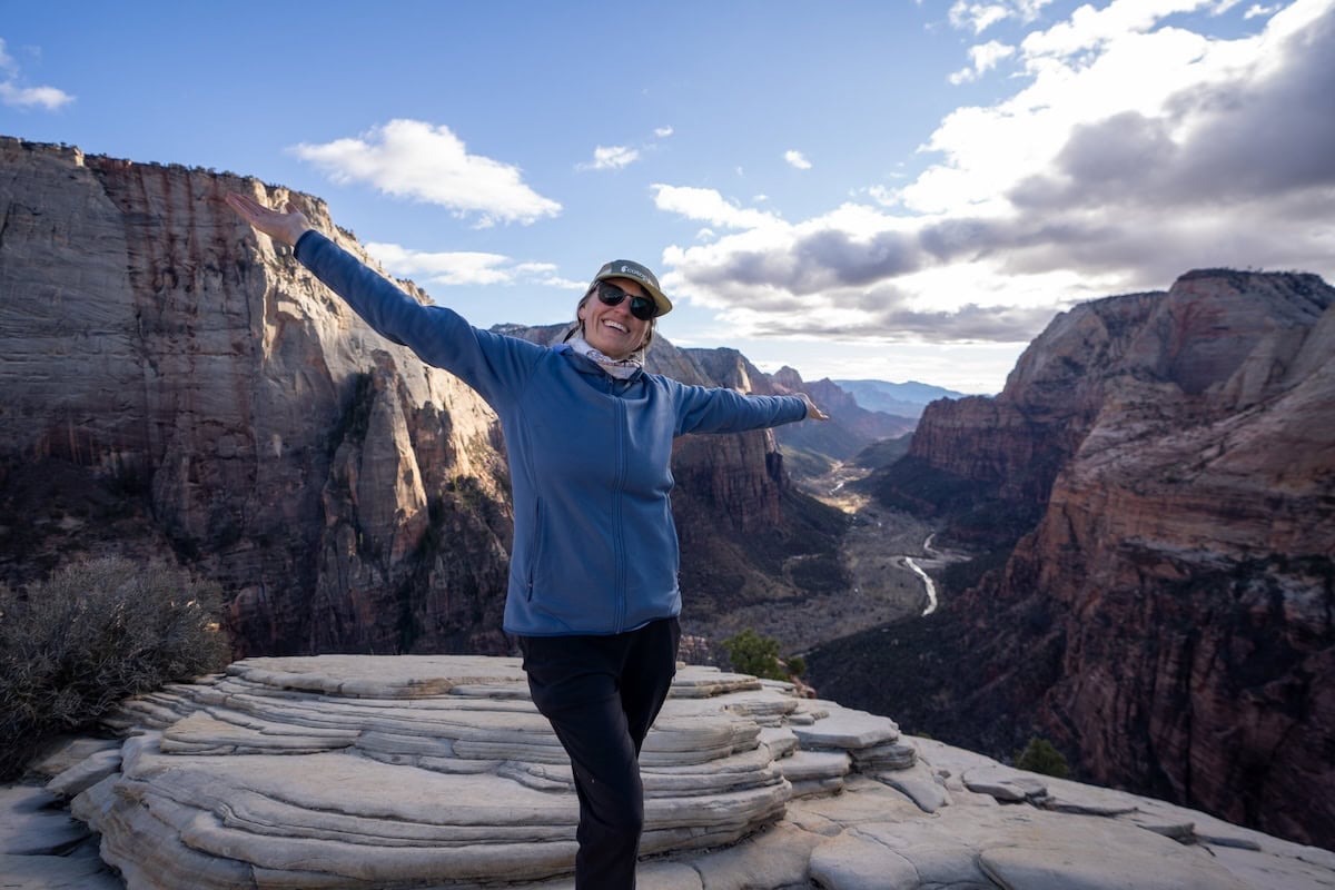 Kristen Bor on the top of Angel's Landing in Zion National Park wearing the Cotopaxi Tech 5 panel hat