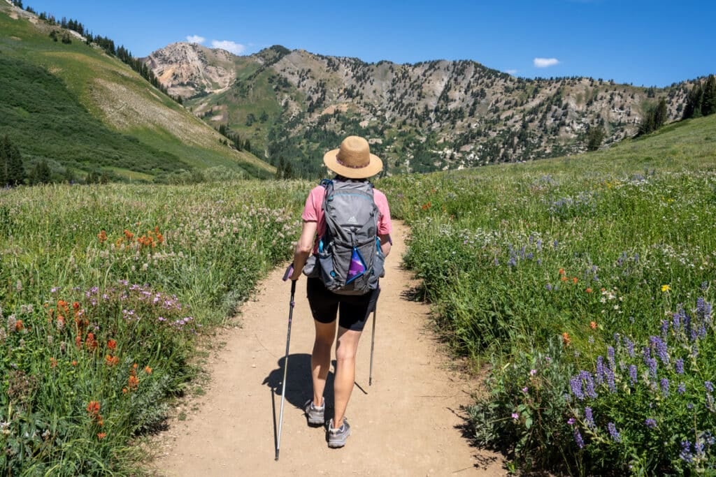 Kristen Bor hiking with a Kula Cloth pee rag hanging on the outside of a hiking backpack